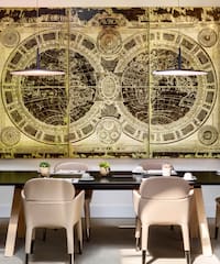 a table with chairs and a large painting on the wall