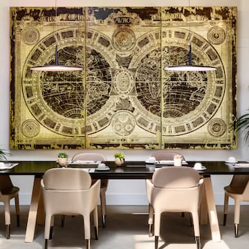 a table with chairs and a large painting on the wall