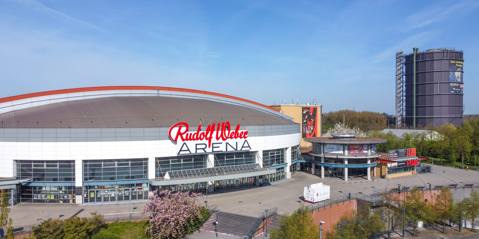 Rudolf Weber Arena with red logo, glass entrance, and gasholder.
