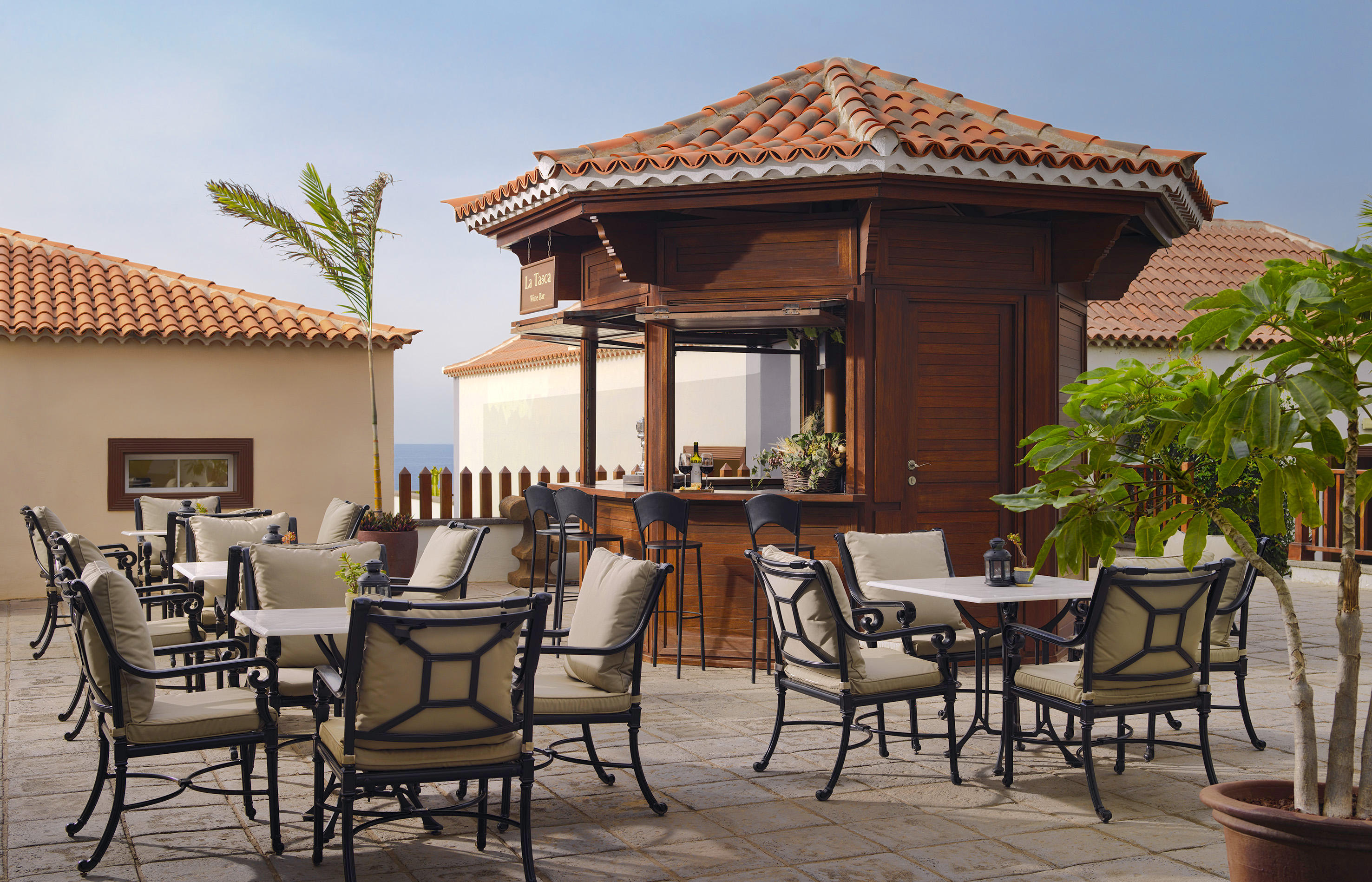 Outdoor La Tasca Wine Bar patio with dining tables, chairs, and tiled roof.