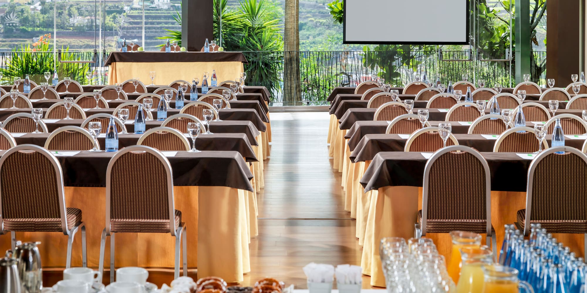 a room with tables and chairs and a screen