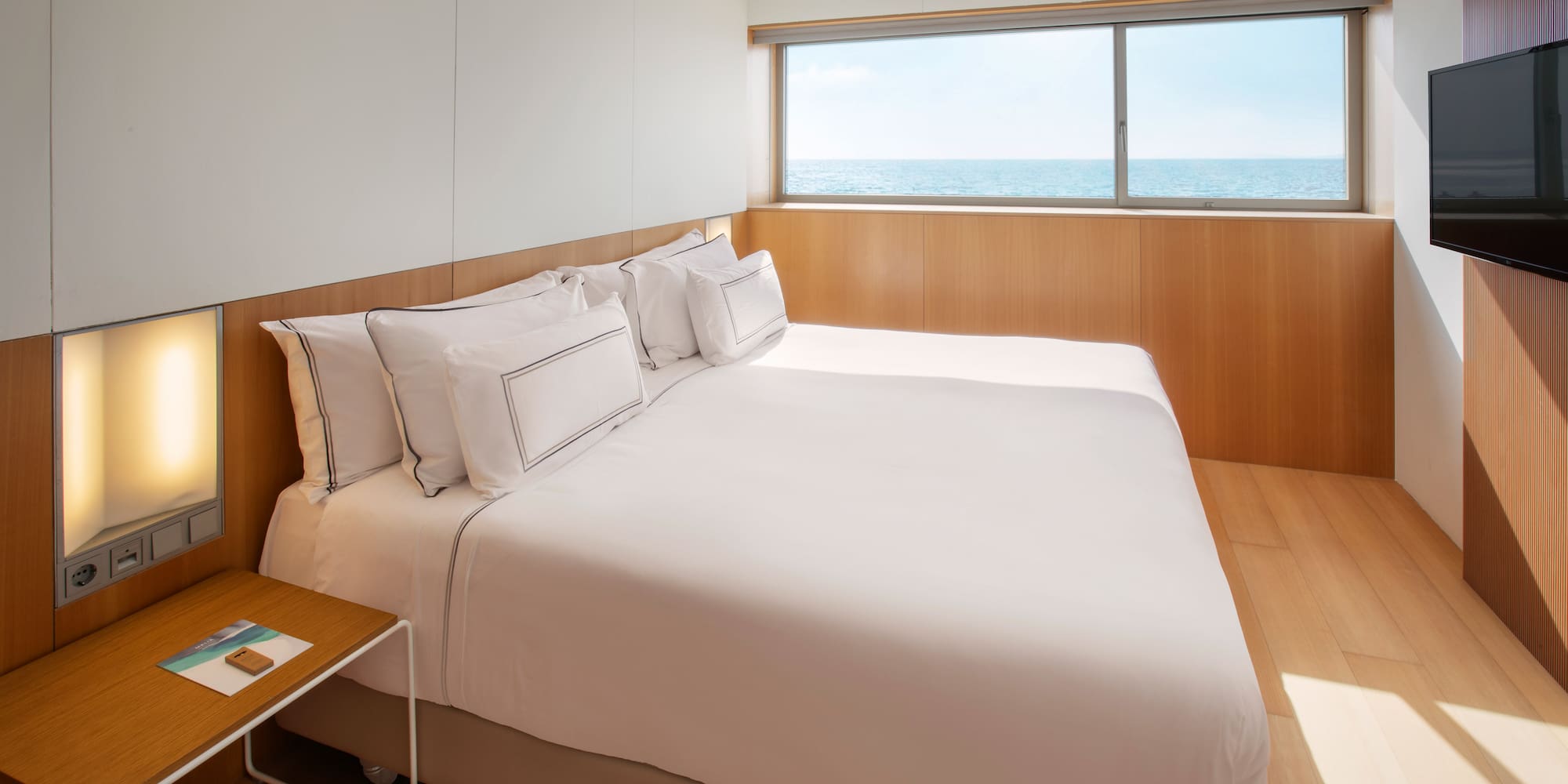 a bed with a window and ocean view