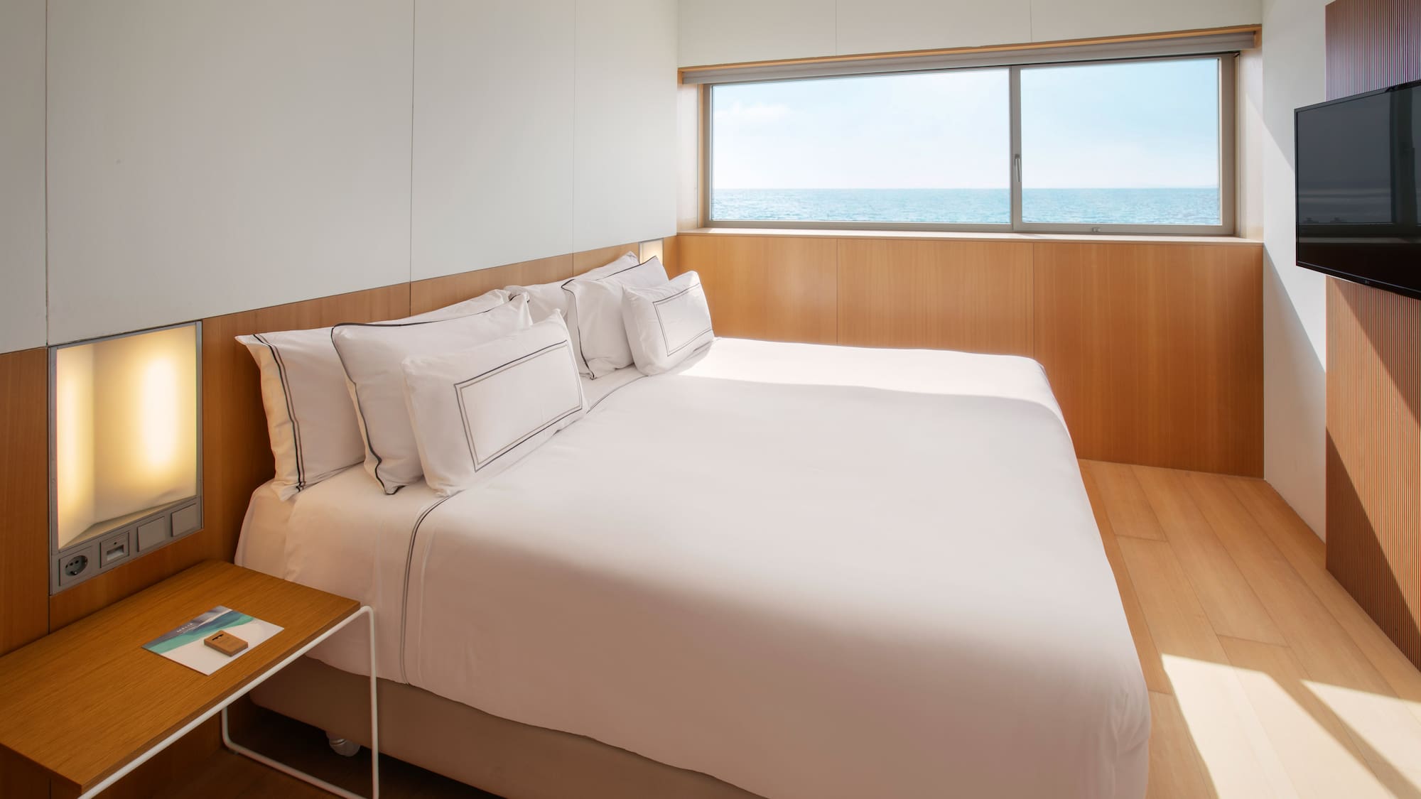 a bed with a window and ocean view