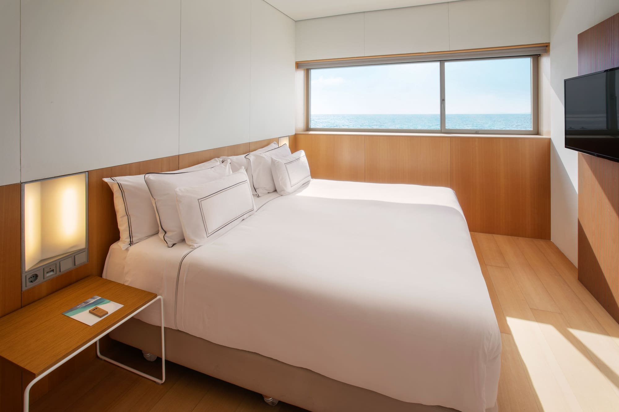 a bed with a window and ocean view