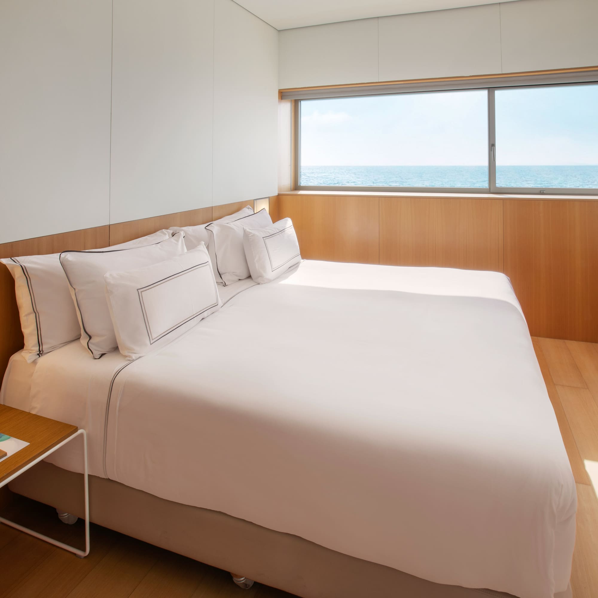 a bed with a window and ocean view