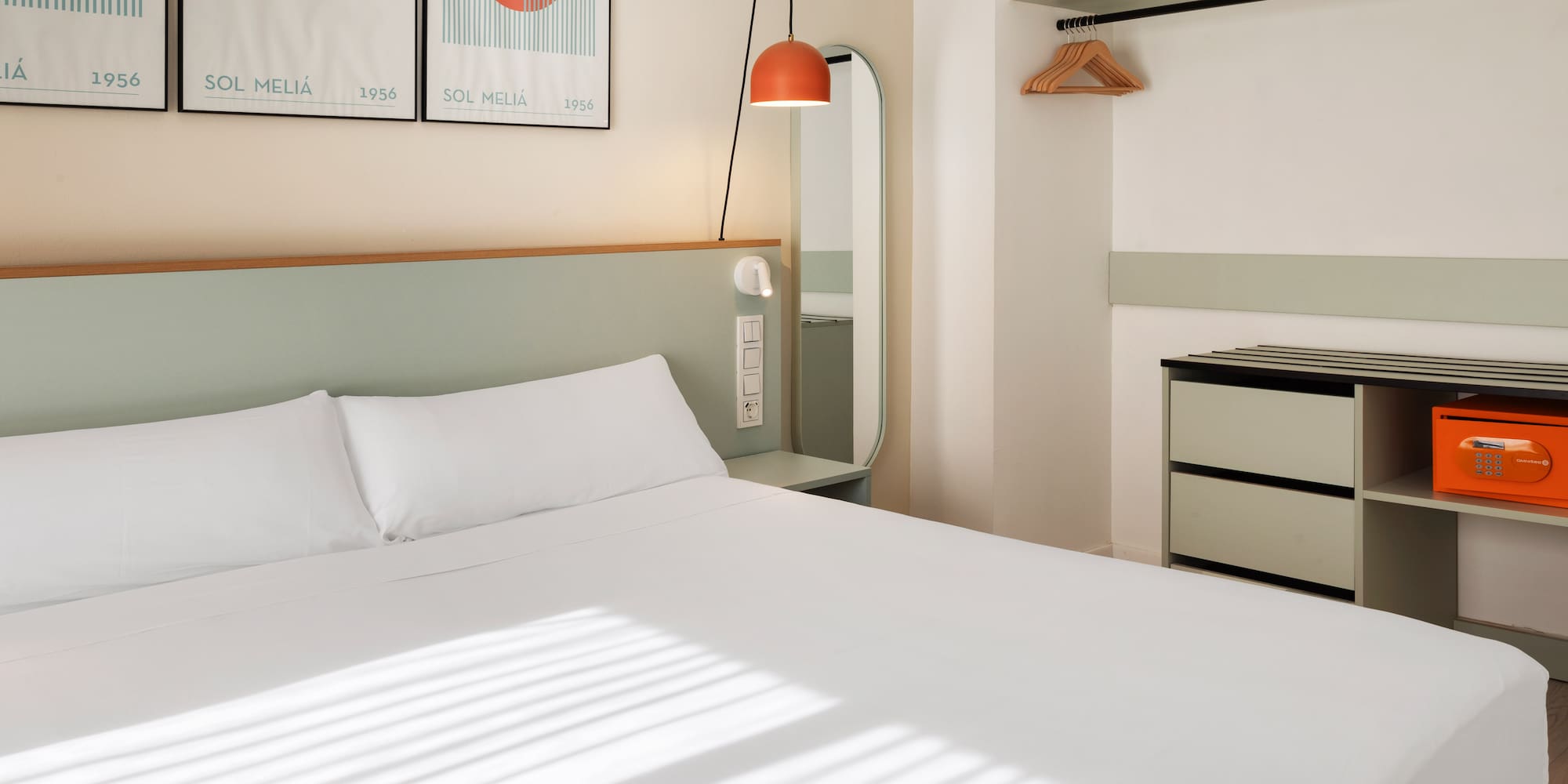 a bed with white sheets and a mirror