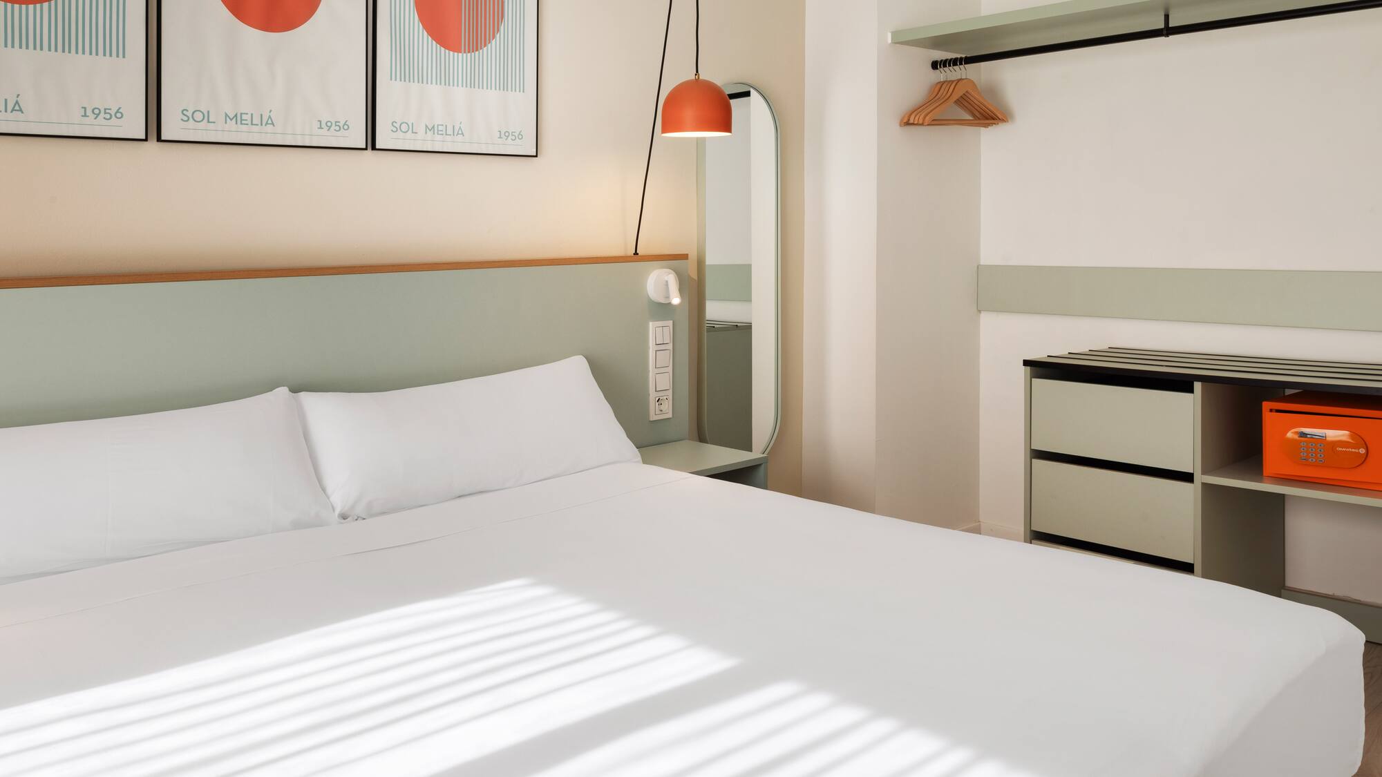 a bed with white sheets and a mirror