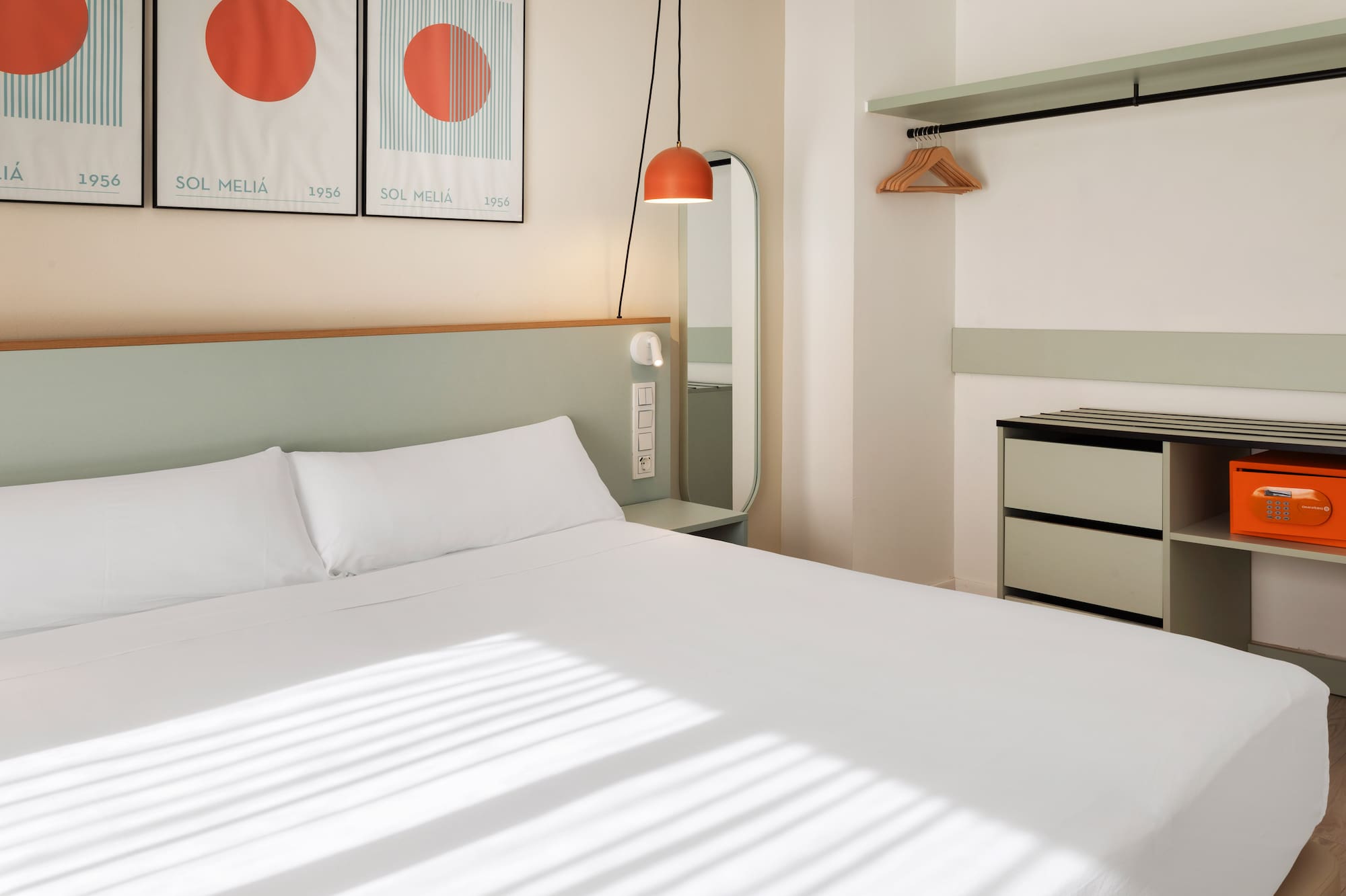 a bed with white sheets and a mirror