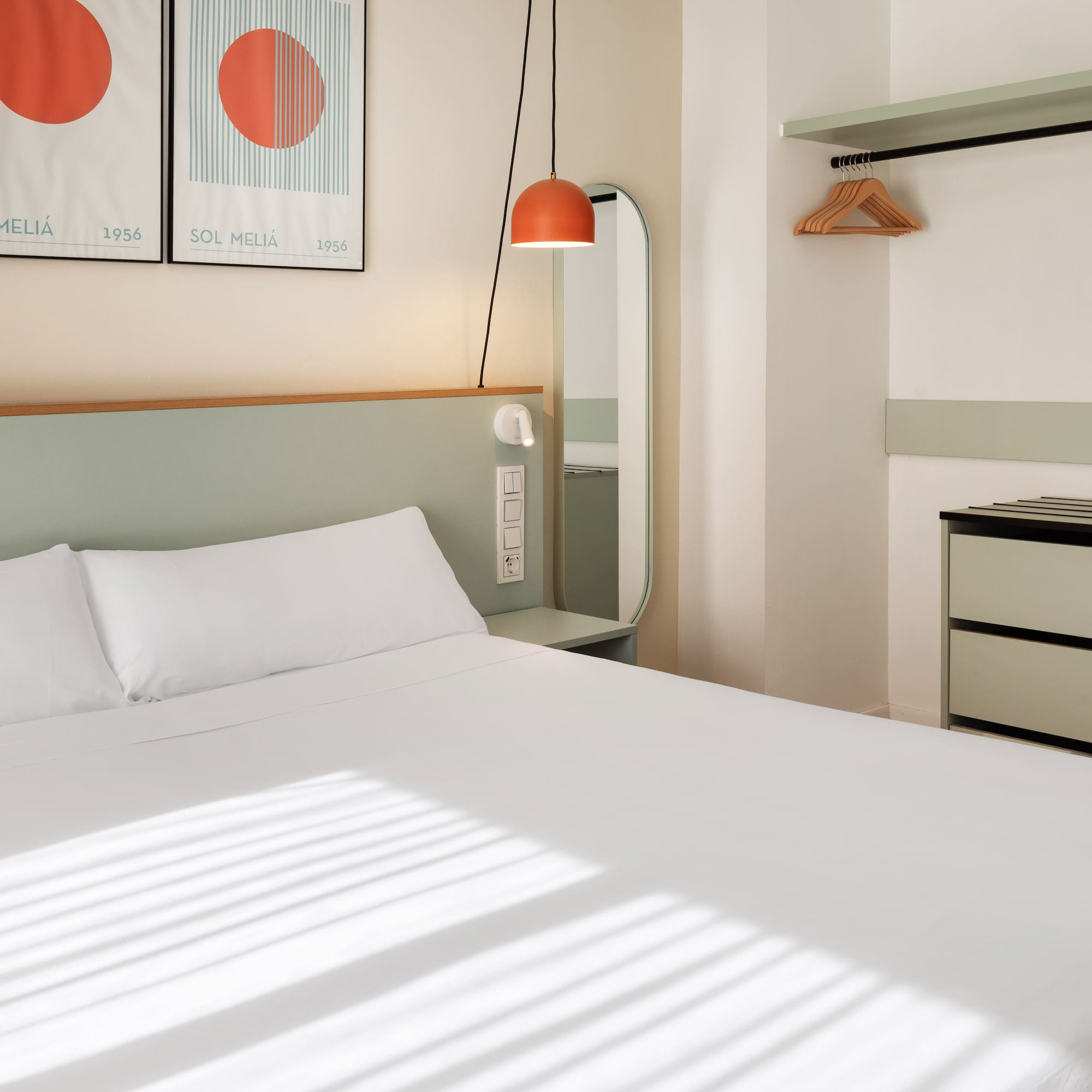 a bed with white sheets and a mirror