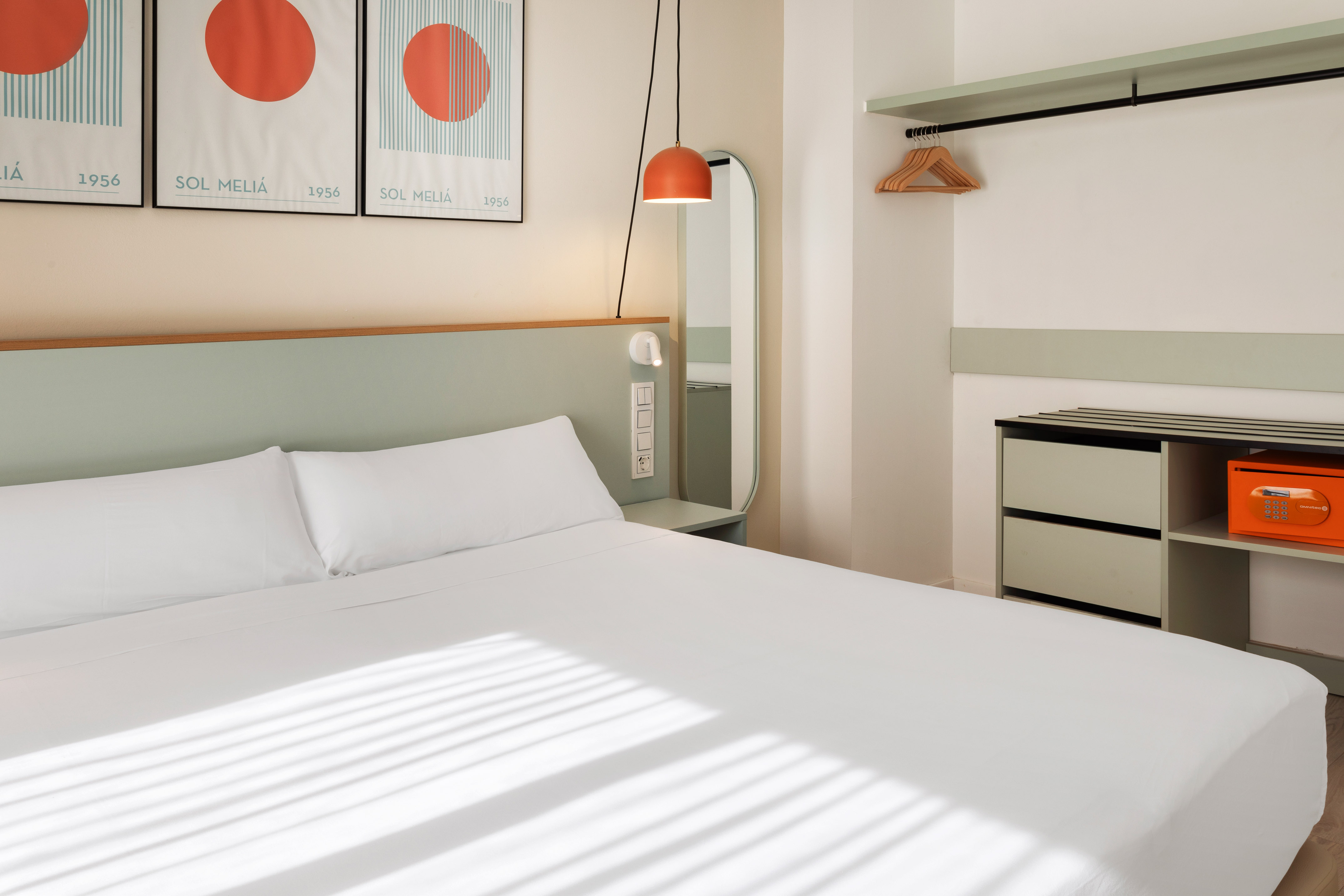 a bed with white sheets and a mirror