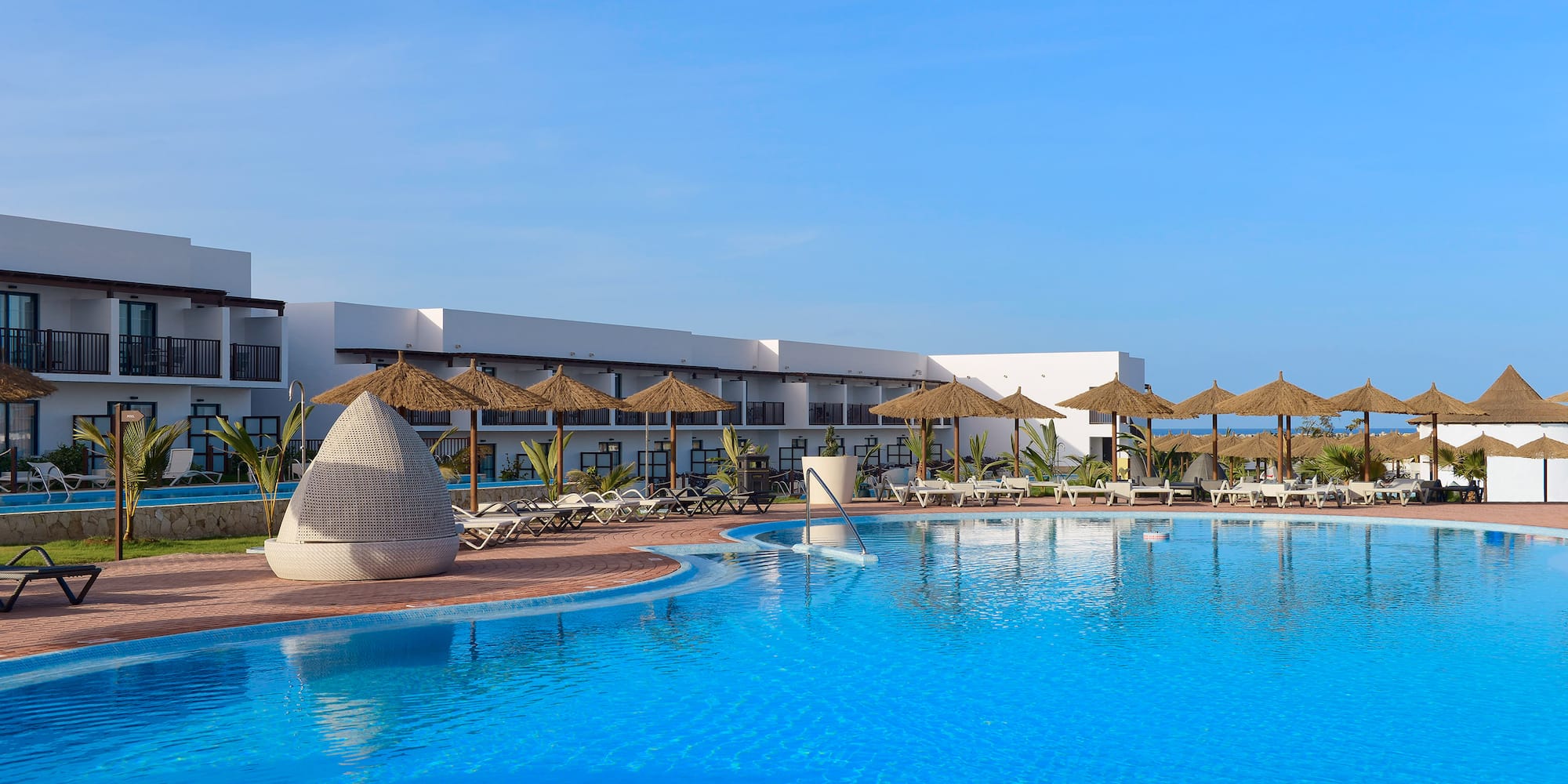 a swimming pool with umbrellas and chairs