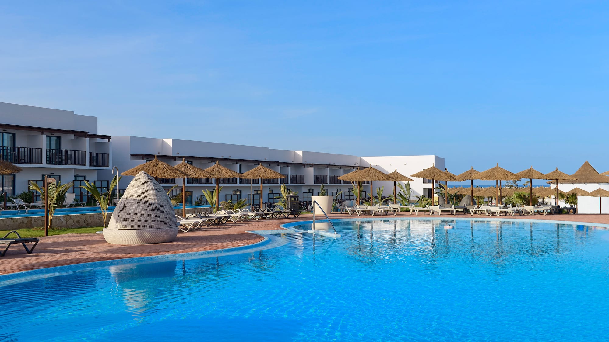 a swimming pool with umbrellas and chairs