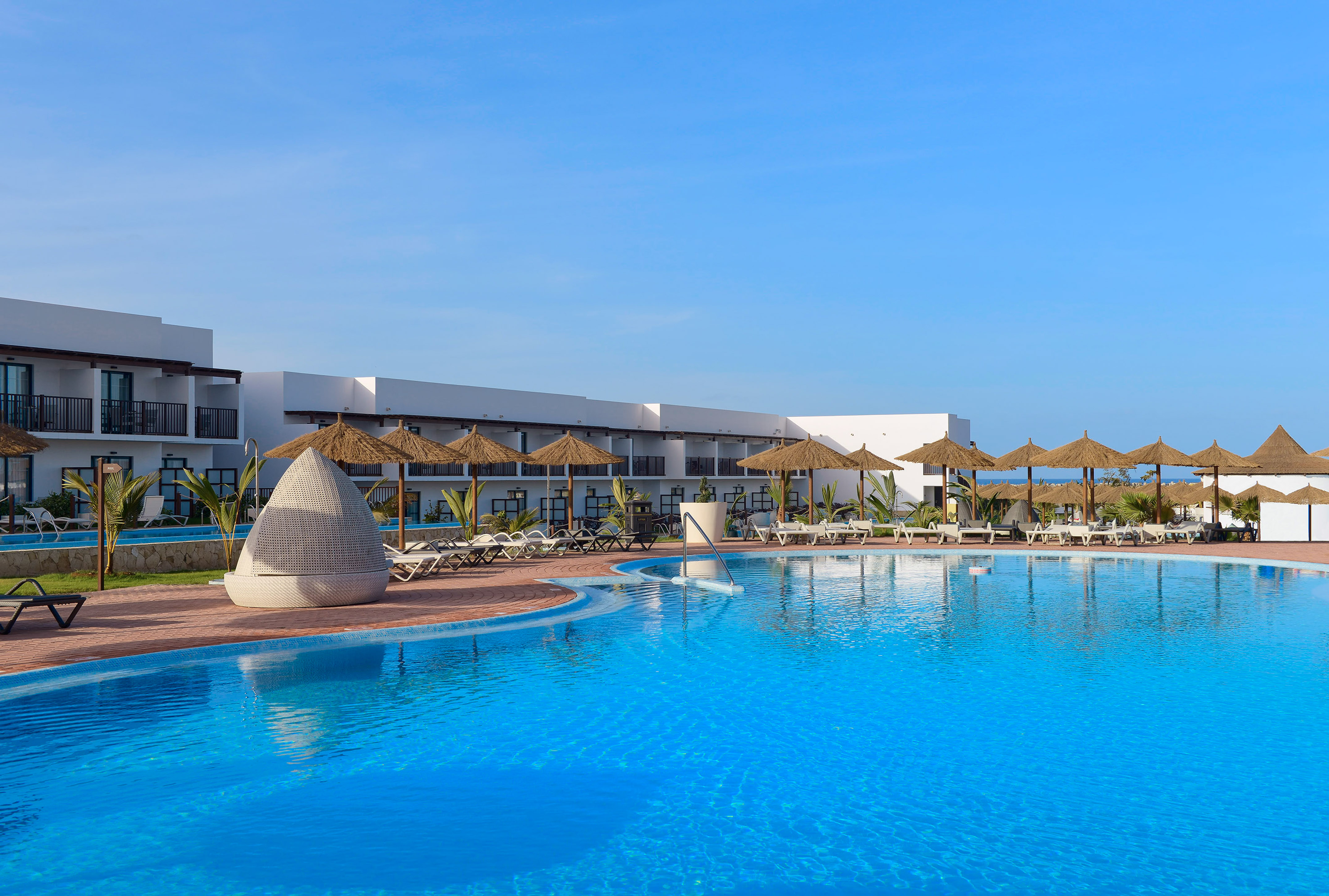a swimming pool with umbrellas and chairs