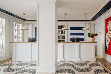 a white and black patterned floor with a white column and a white counter