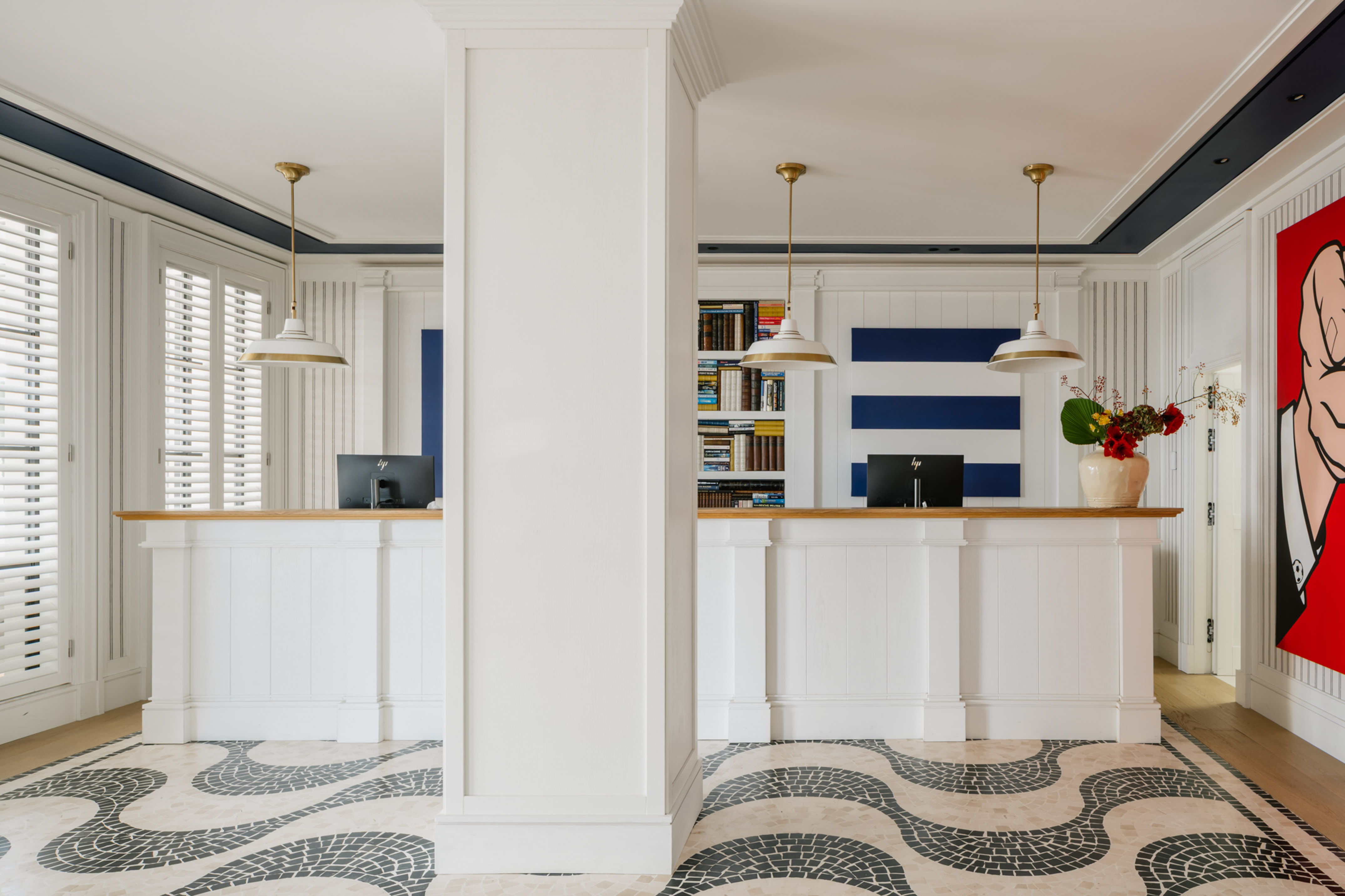 a white and black patterned floor with a white column and a white counter