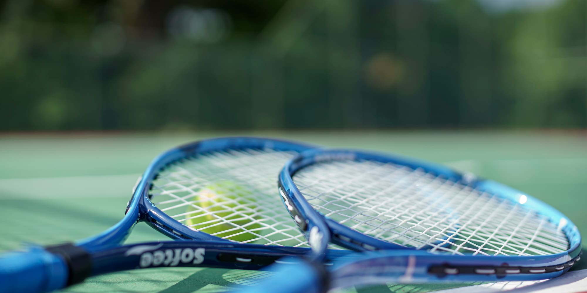 a tennis rackets and a ball on a tennis court