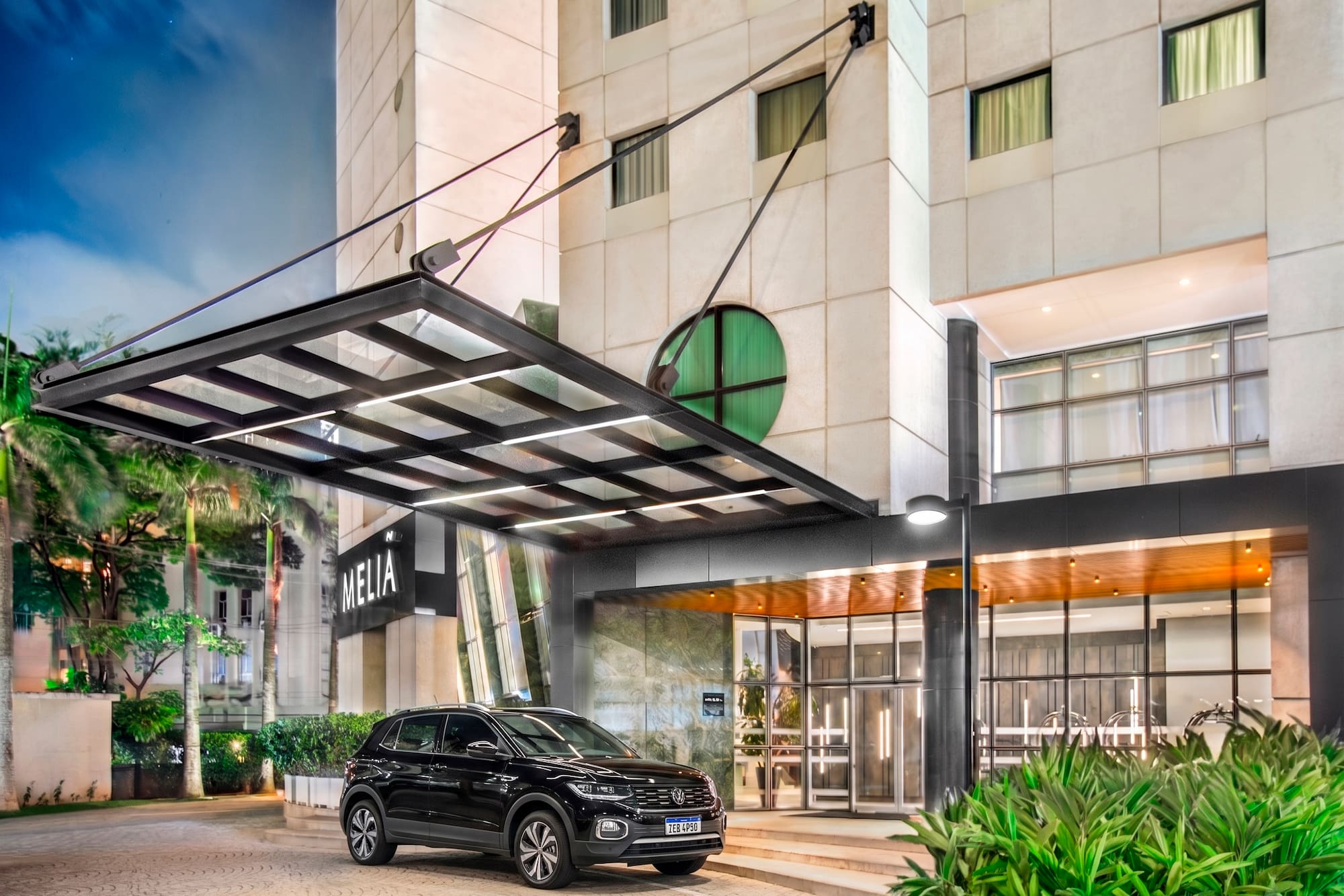 Hotel Meliá de noche, SUV negro en entrada principal iluminada con palmeras.