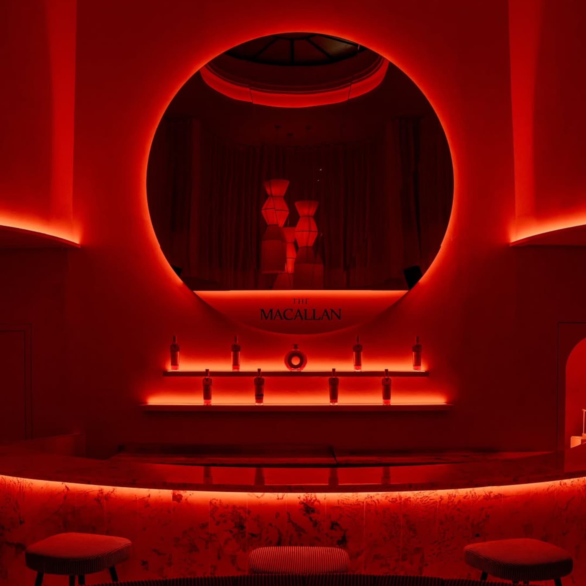 a red lit room with a round mirror