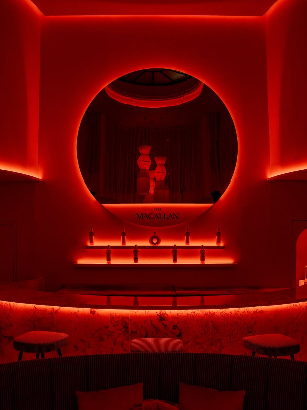 a red lit room with a round mirror