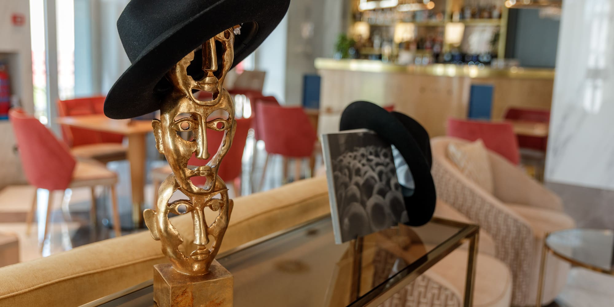 a gold statues with black hats on a glass table