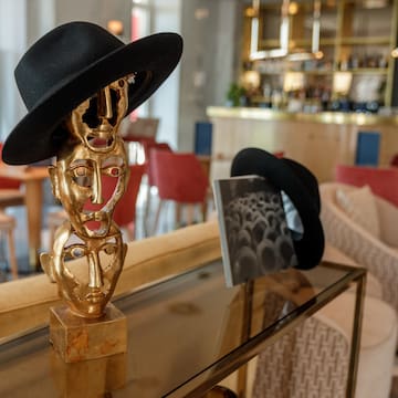 a gold statues with black hats on a glass table