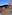 Modern outdoor lounge patio, mountain view at twilight, resort terrace.