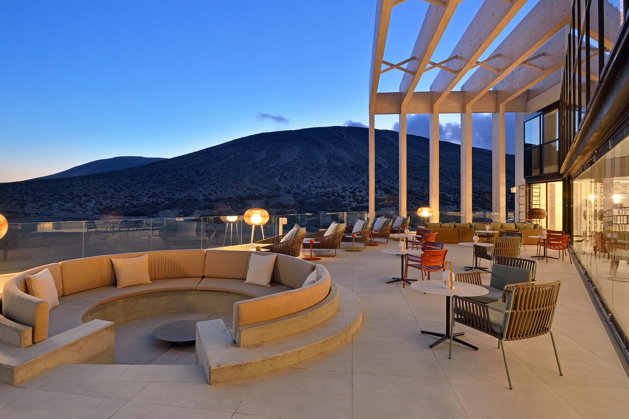 a large outdoor patio with a round couch and tables