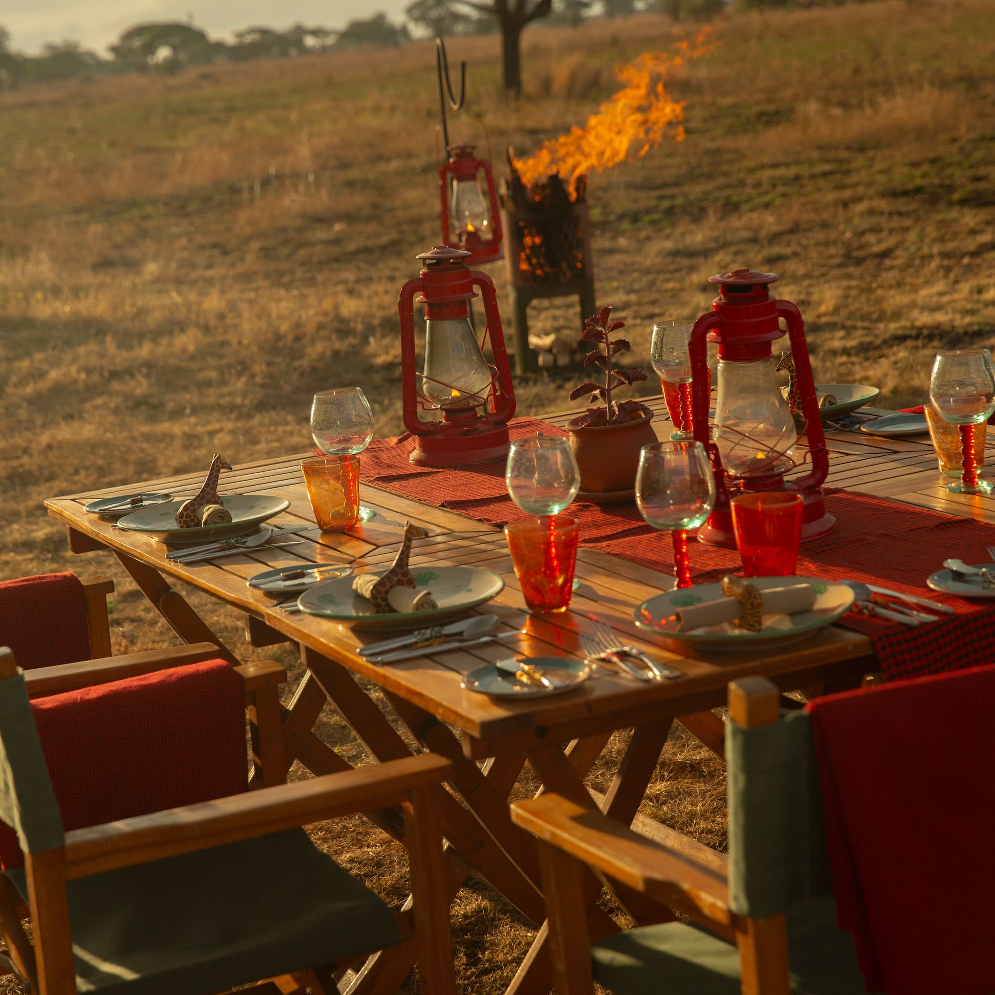 a table set for a dinner with a fire in the background