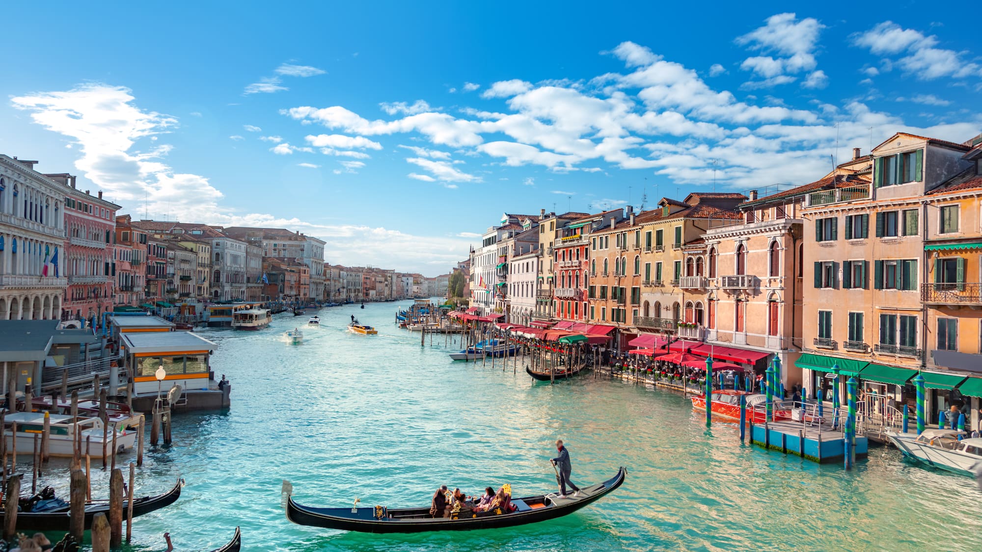 a canal with boats and buildings in the background with Grand Canal in the background