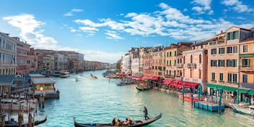 a canal with boats and buildings in the background with Grand Canal in the background