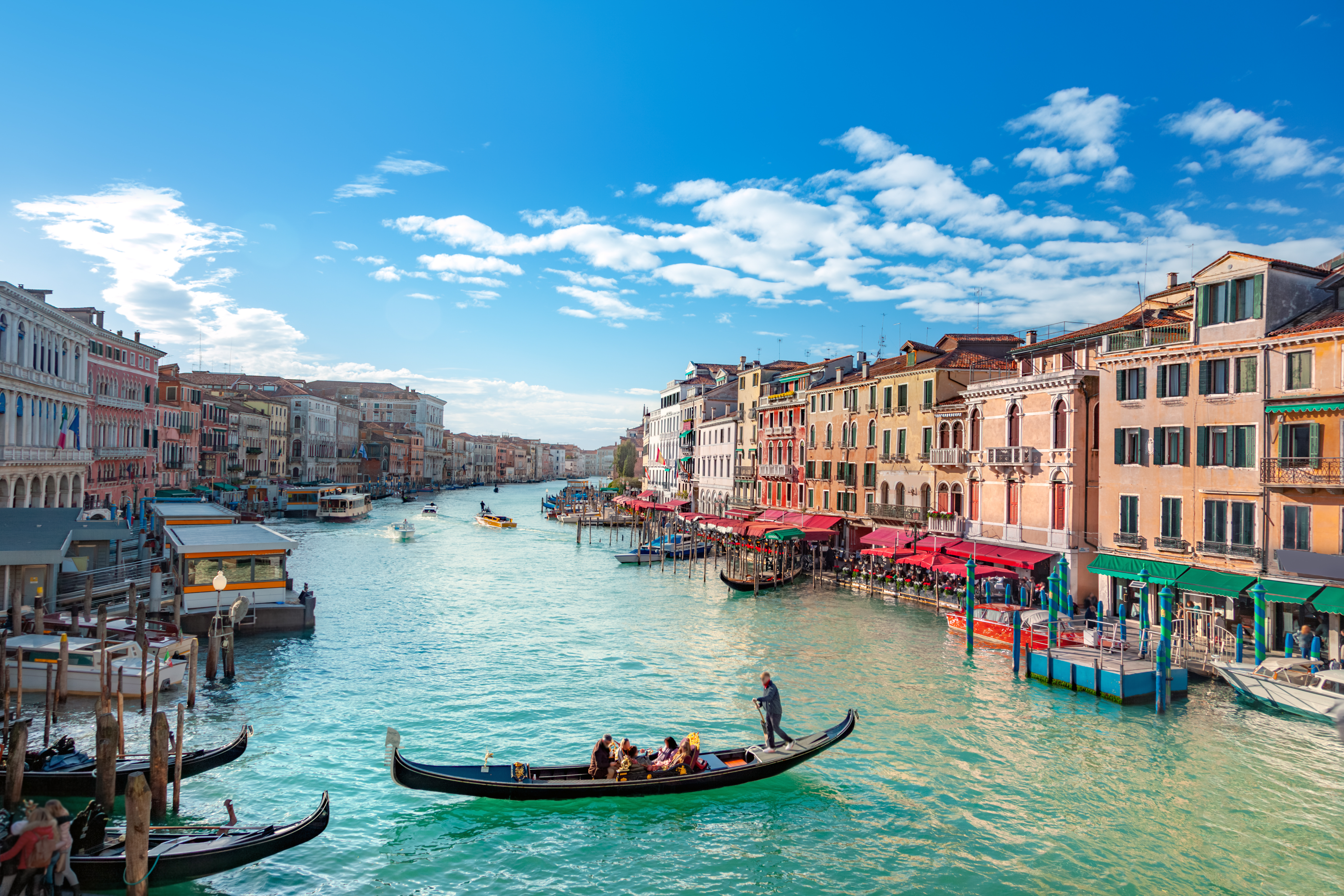 a canal with boats and buildings in the background with Grand Canal in the background