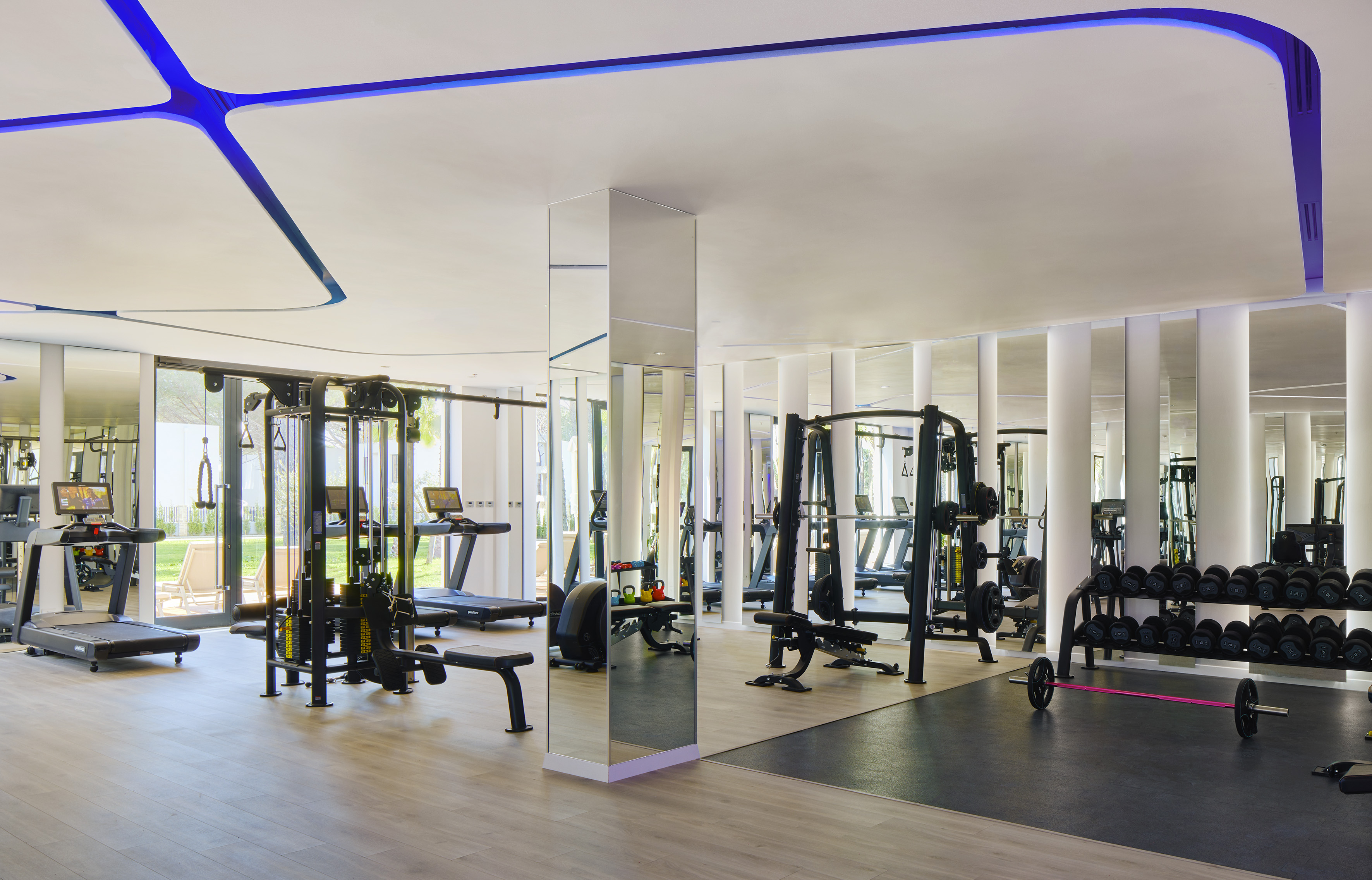 Modern, spacious gym with treadmills, free weights, and workout machines.
