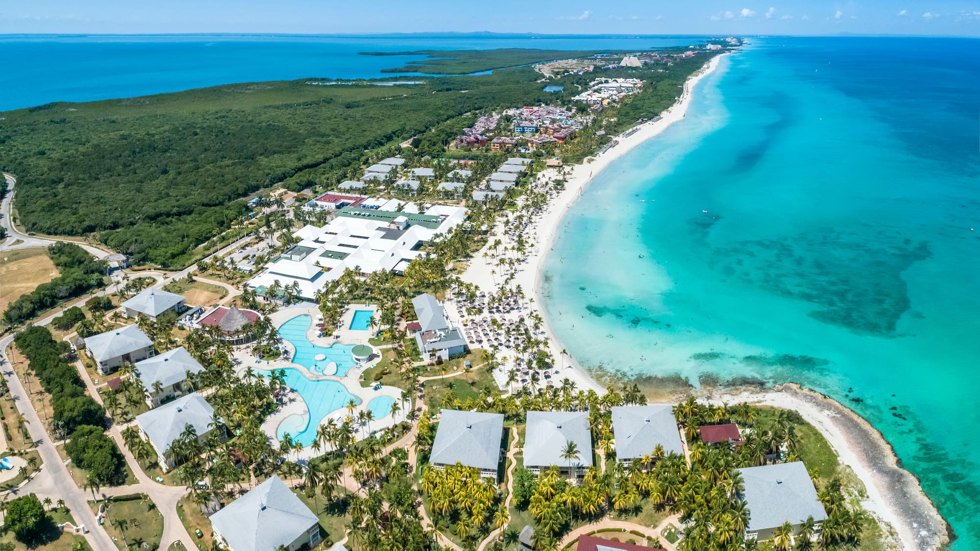 a beach with buildings and a body of water