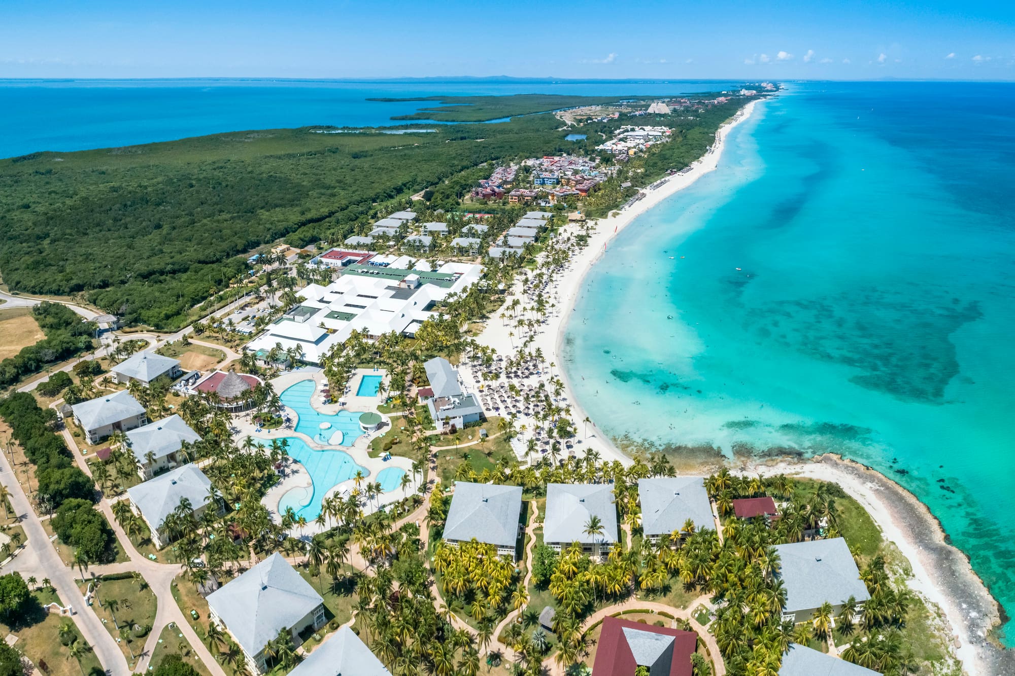 a beach with buildings and a body of water