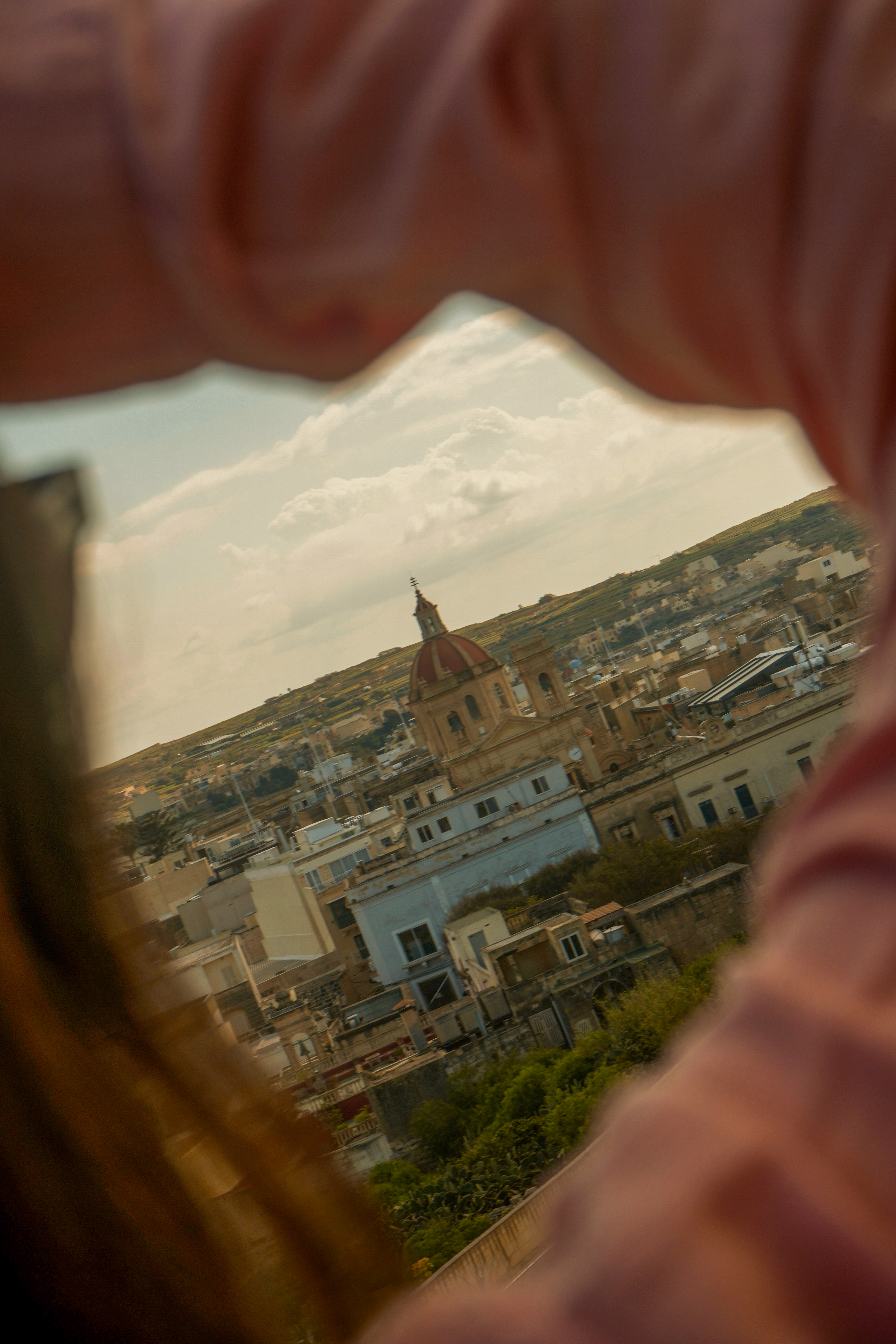 View of a Mediterranean town and red-domed church through abstract framing.