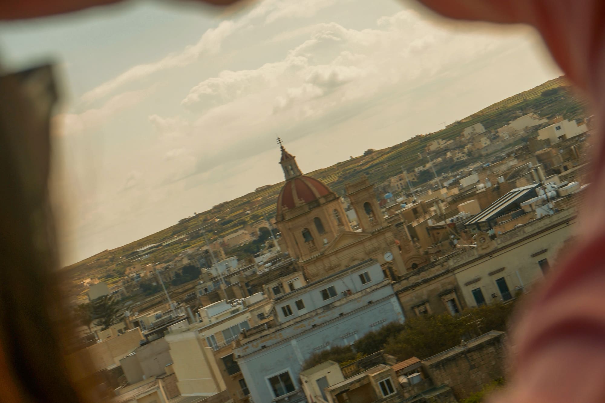 View of a Mediterranean town and red-domed church through abstract framing.