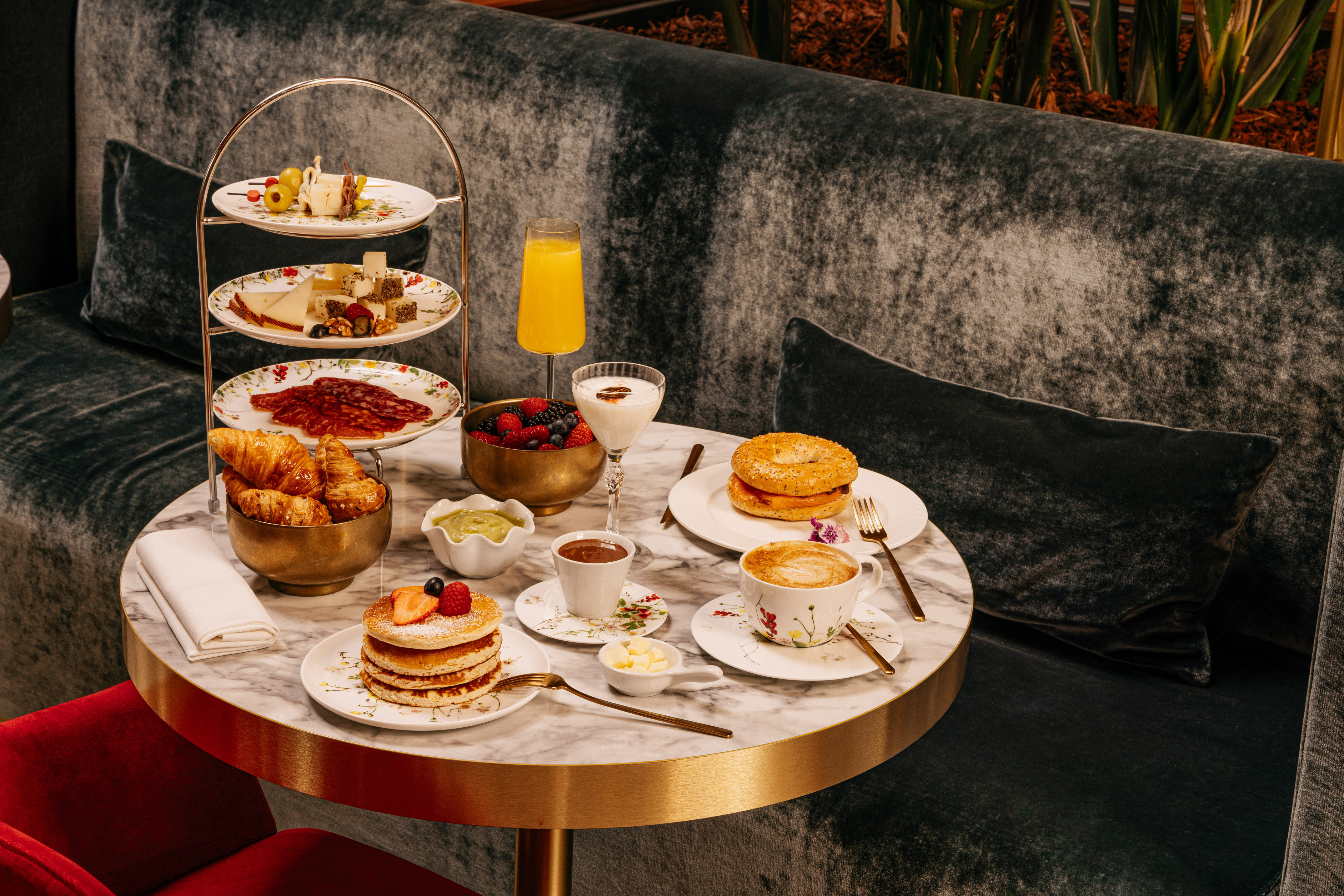 Full breakfast spread: pancakes, pastries, cheese, charcuterie, coffee, juice.