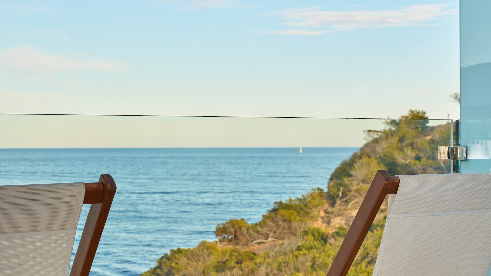 chairs on a balcony overlooking the ocean