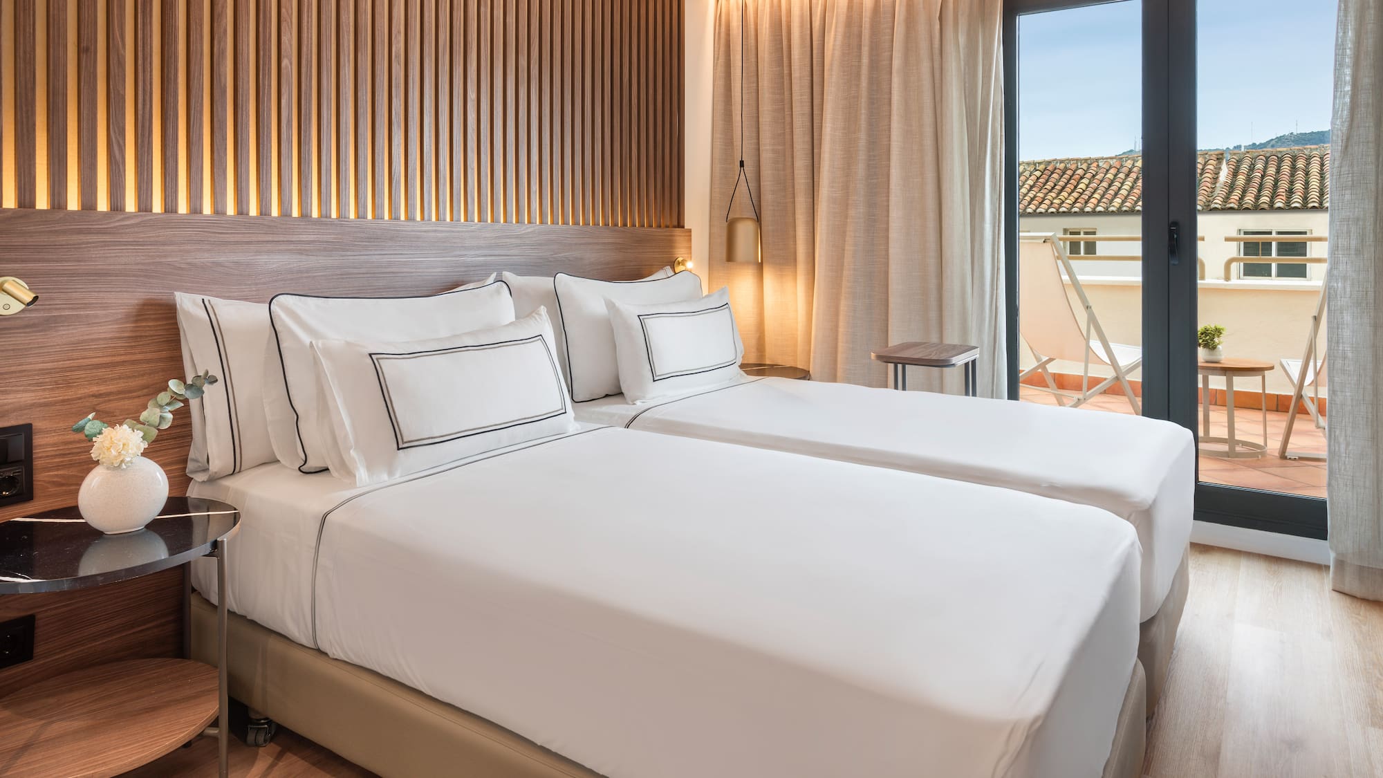 a room with two beds and a glass door