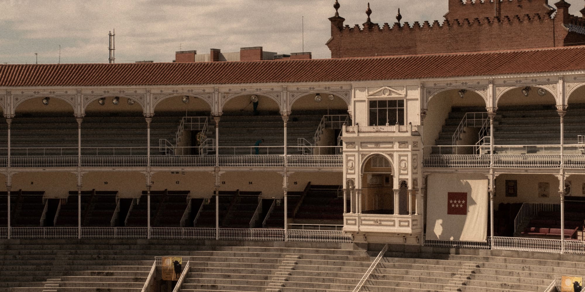 an empty stadium with seating and a building