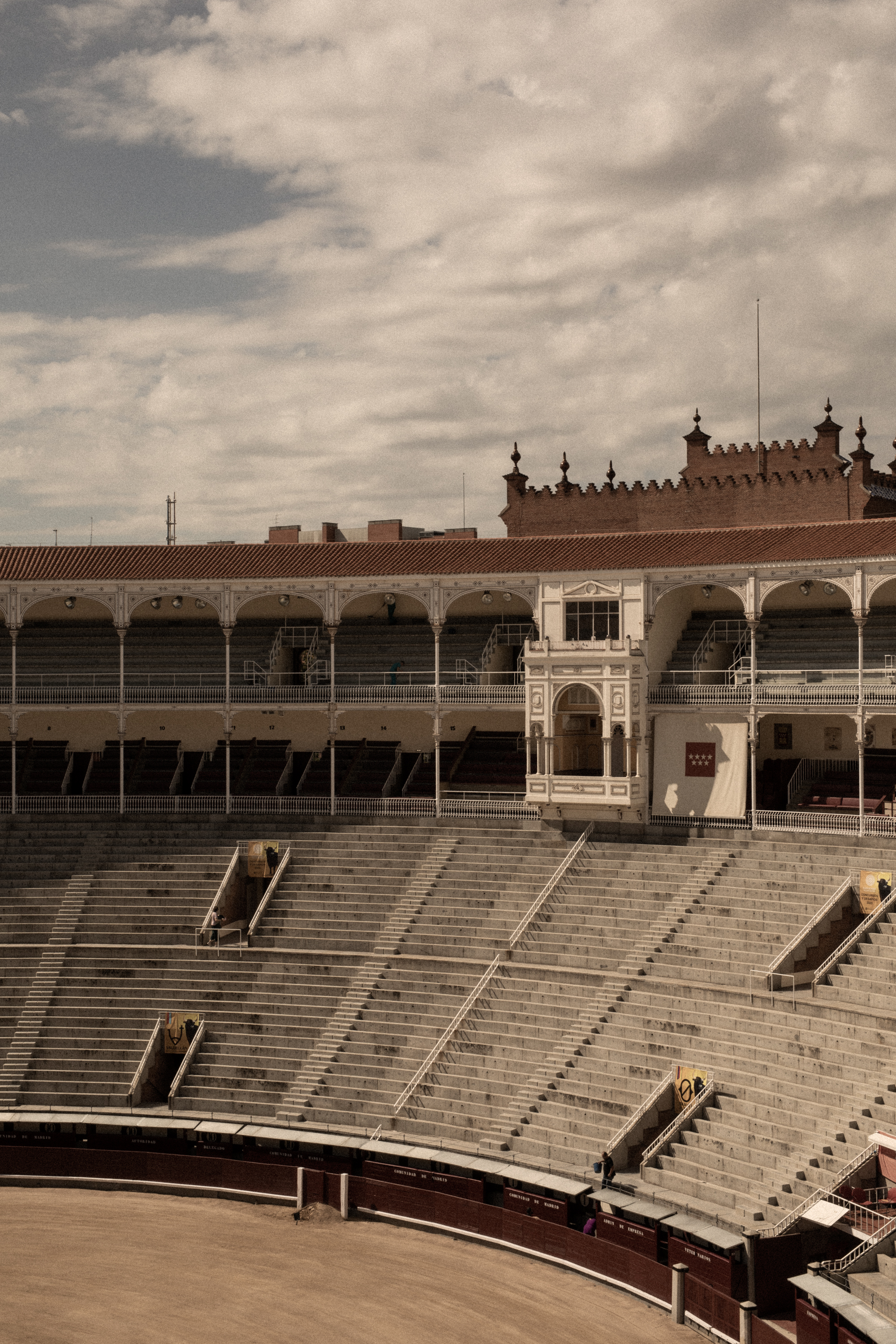 an empty stadium with seating and a building