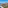 Coastal resort panorama: beach, marina, hotels, city buildings, and hill.
