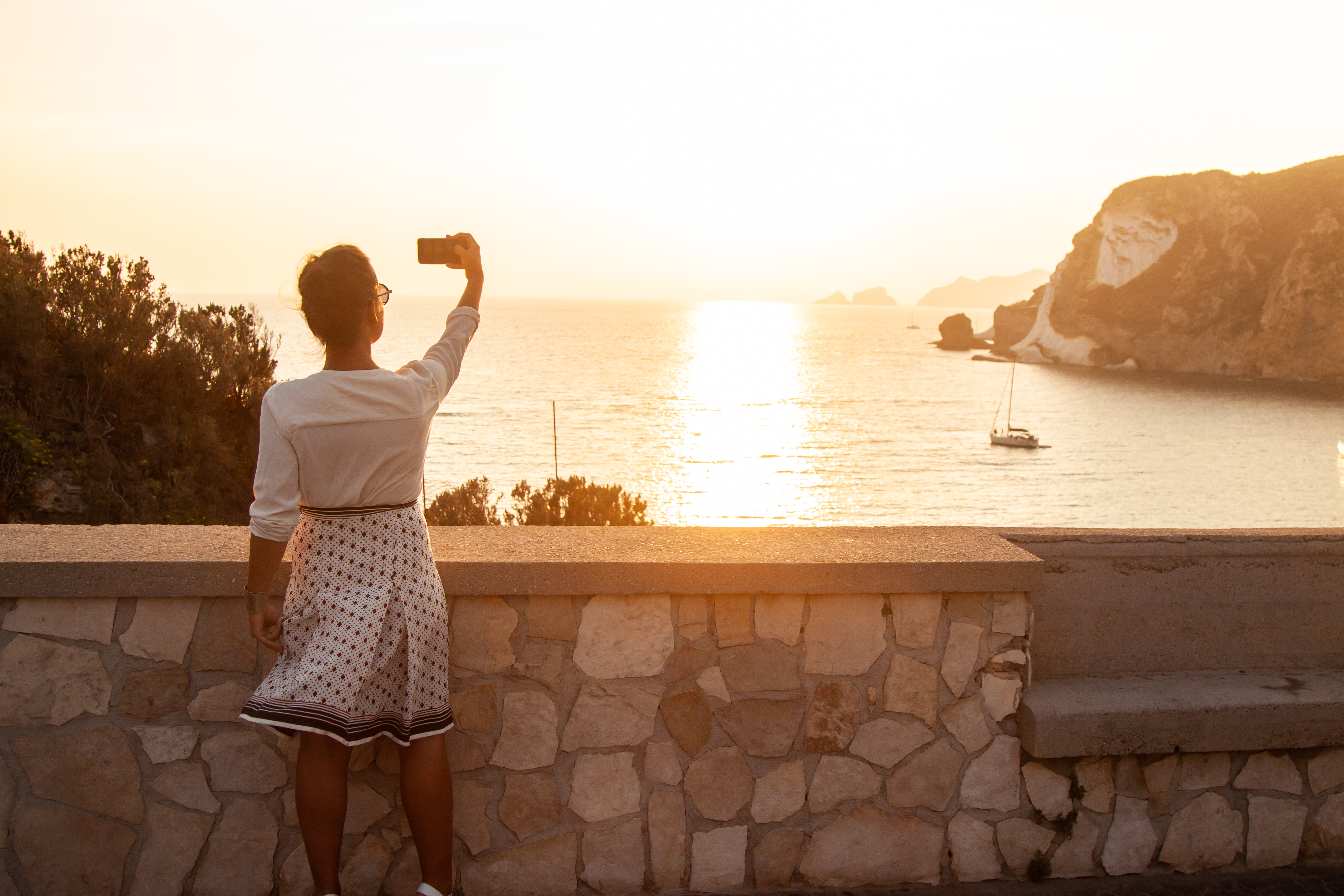 a woman taking a picture of the ocean