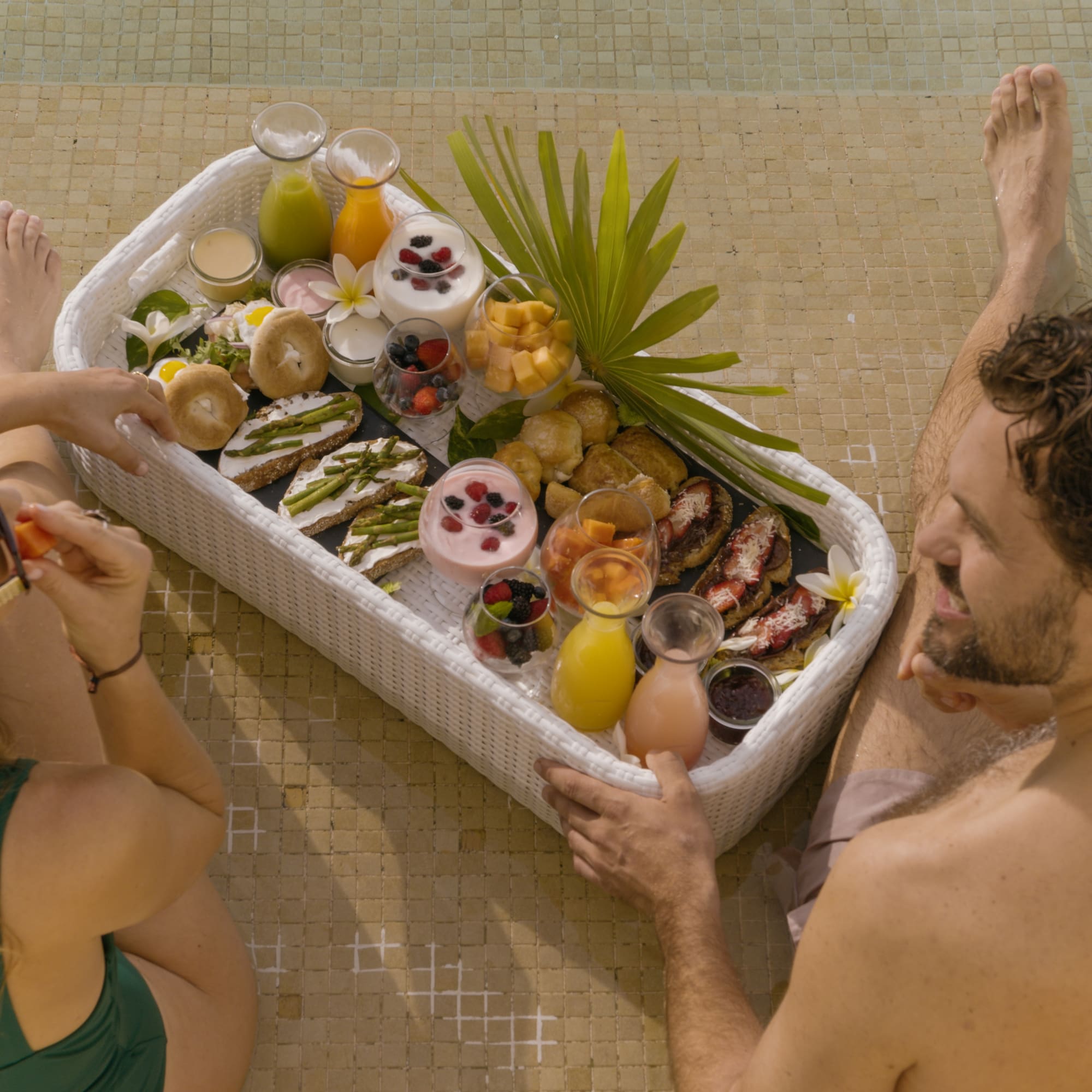 a man and woman sitting next to a basket of food