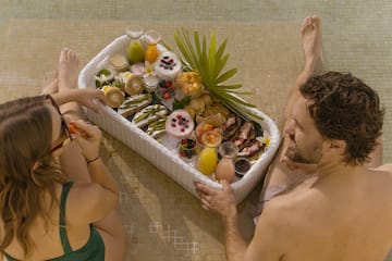 a man and woman sitting next to a basket of food
