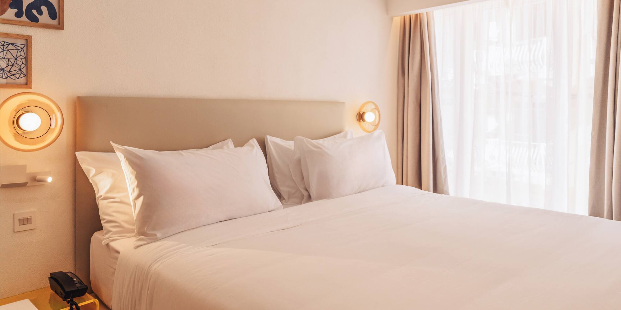 a bed with white sheets and pillows