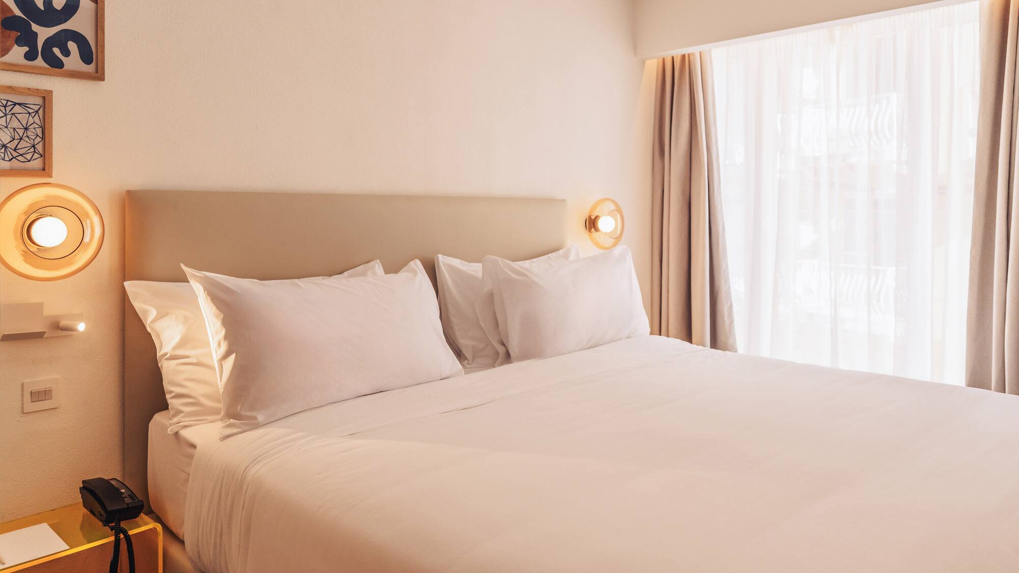 a bed with white sheets and pillows