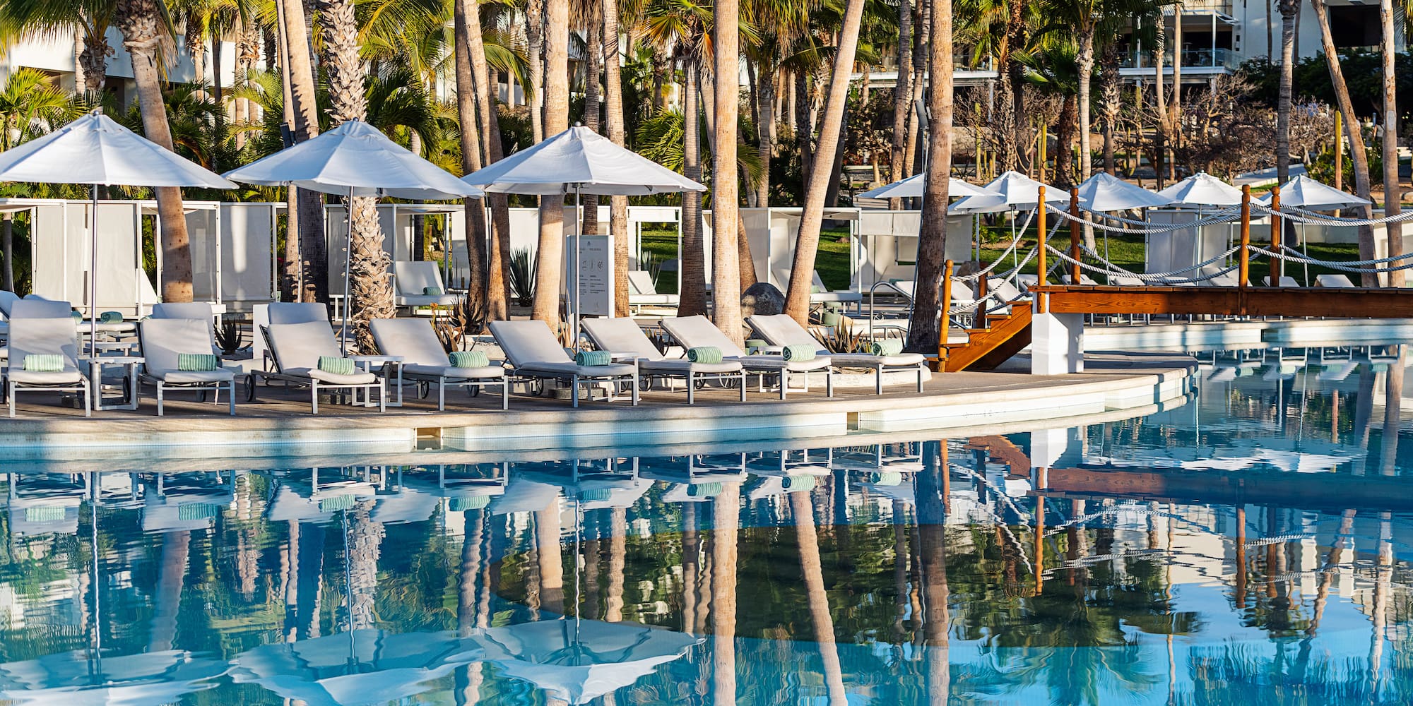 a pool with lounge chairs and umbrellas