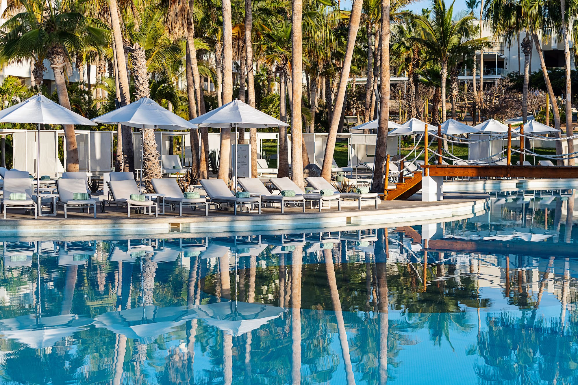 a pool with lounge chairs and umbrellas