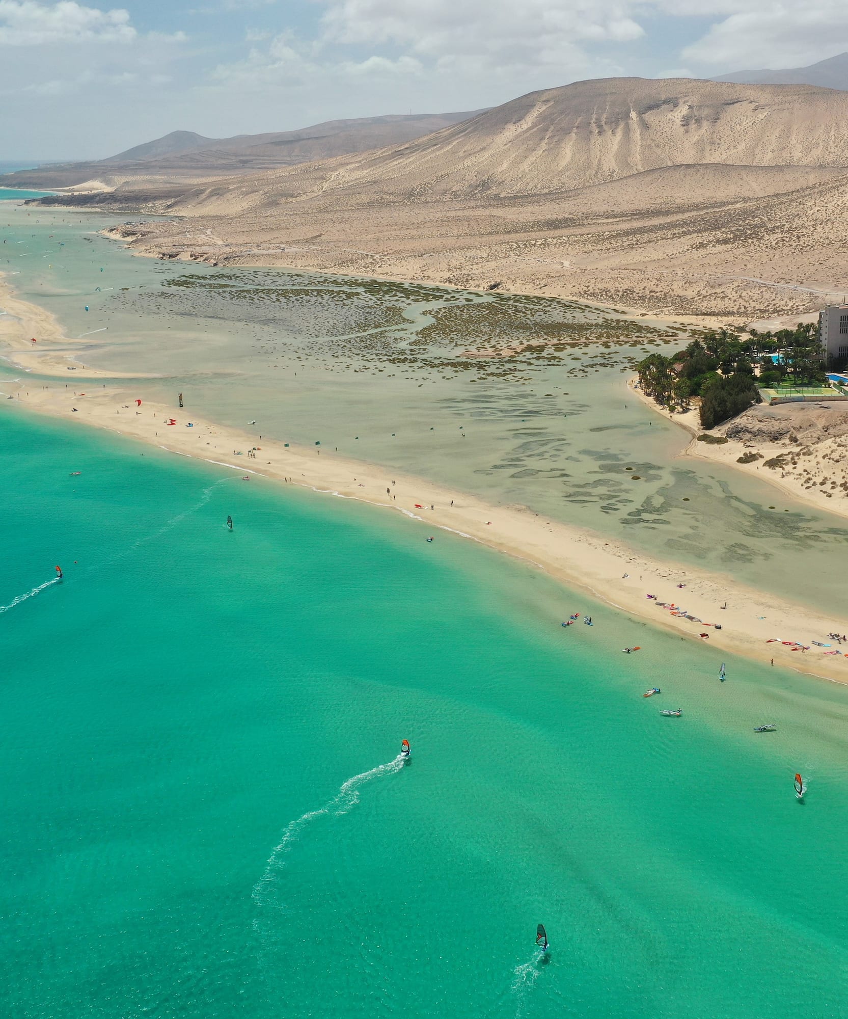 Playa Fuerteventura: mar turquesa, windsurf, kitesurf en laguna, dunas áridas.
